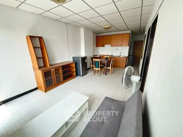Spacious living room with dining area and modern furniture in open layout apartment.