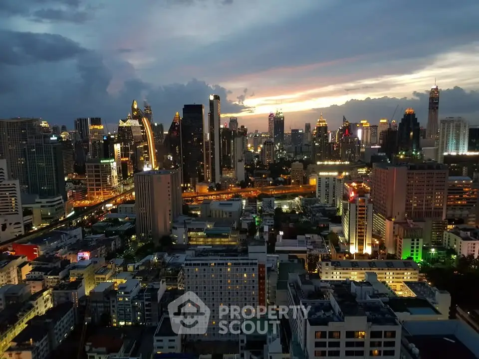 Stunning cityscape view from a high-rise building at sunset, showcasing vibrant city lights and skyline.