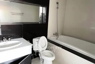 Modern bathroom with sleek black and white design featuring a bathtub and stylish fixtures.