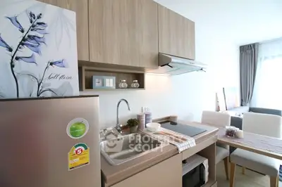 Modern kitchen with sleek cabinetry and dining area in open layout apartment.
