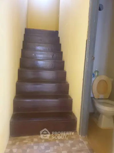 Cozy interior staircase with adjacent bathroom in a compact home setting.