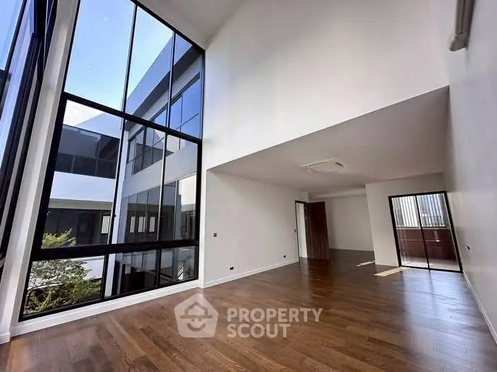 Spacious modern living room with high ceilings and large windows offering ample natural light.