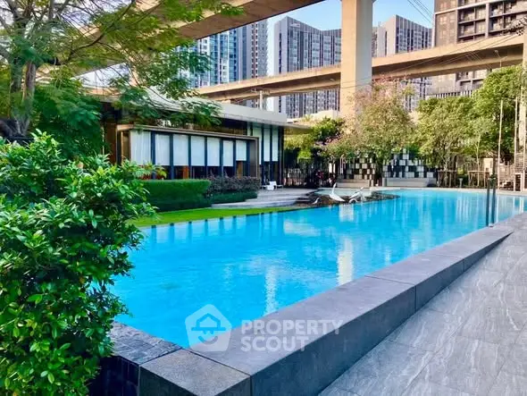 Luxurious outdoor pool area with modern architecture and lush greenery.