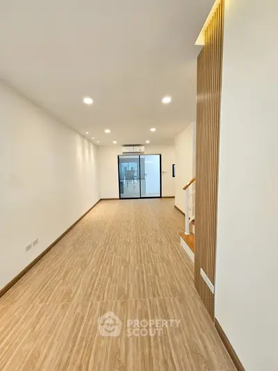 Spacious modern living room with wooden flooring and recessed lighting