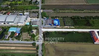Aerial view of rural landscape with fields and buildings, showcasing potential real estate development.