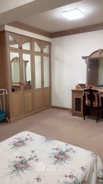 Spacious bedroom with mirrored wardrobe and elegant vanity desk