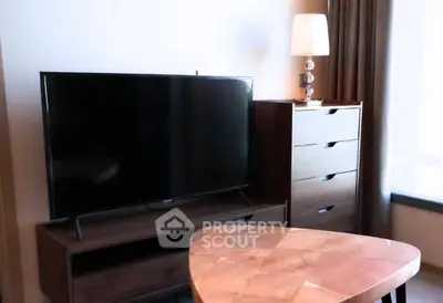 Modern living room with sleek TV, stylish lamp, and elegant wooden furniture.