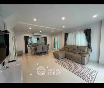 Spacious modern living room with elegant dining area and cozy seating.