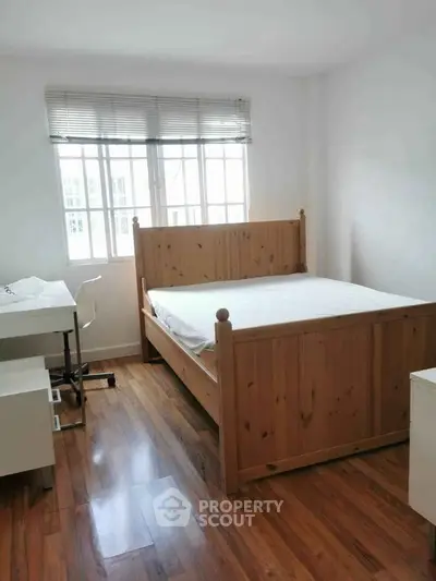 Cozy bedroom with wooden bed frame and natural light