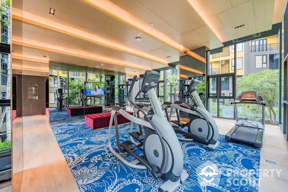 Luxurious gym with modern equipment and scenic garden views in upscale residential complex.