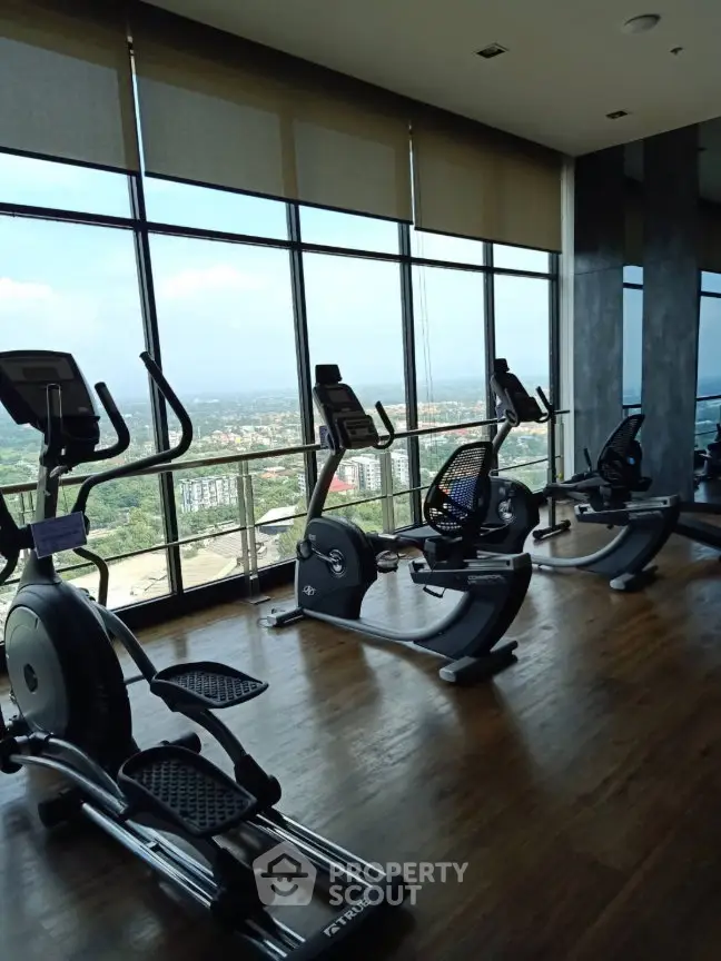 Luxurious high-rise gym with panoramic city views and modern exercise equipment.