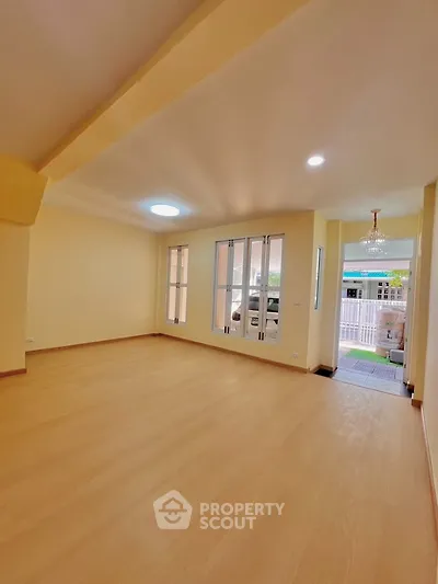 Spacious empty living room with large windows and wooden flooring