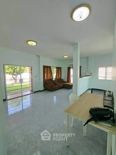 Spacious living room with large windows and modern furniture, perfect for family gatherings.