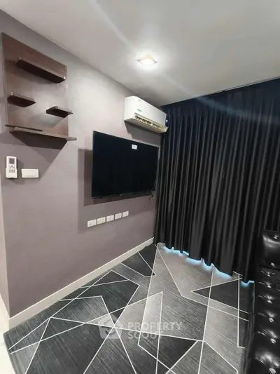 Modern living room with geometric floor design and wall-mounted TV