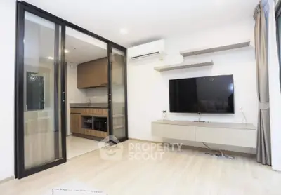 Modern living room with sleek TV setup and open kitchen layout