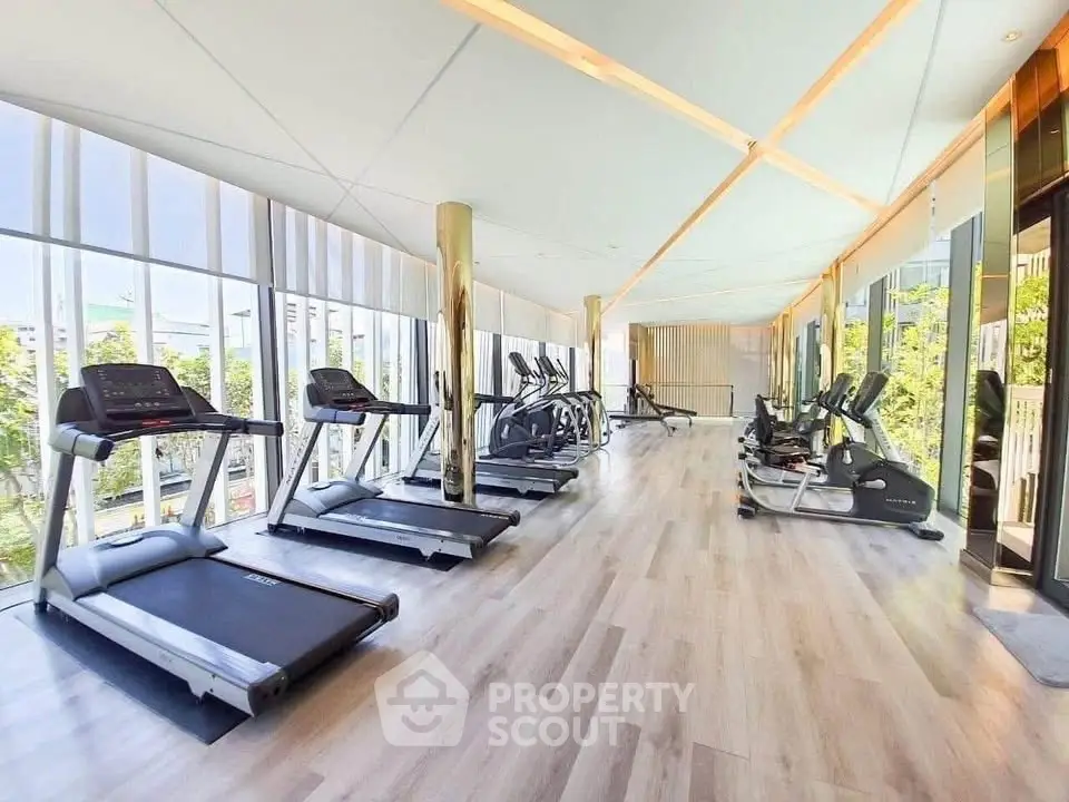 Luxurious gym with modern equipment and panoramic windows in upscale residential building.