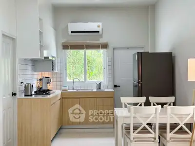 Modern kitchen with wooden cabinets, gas stove, and sleek appliances in a bright, airy space.