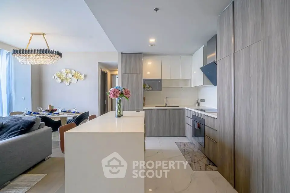 Modern open-plan kitchen and living room with elegant decor and natural light.