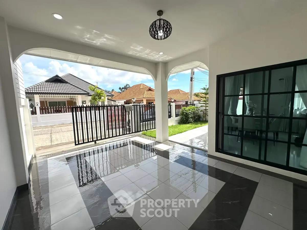 Spacious modern home entrance with sleek tiled flooring and large windows, offering a welcoming ambiance.