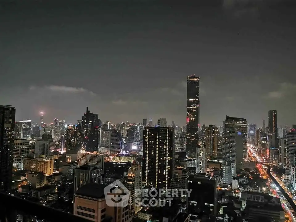 Stunning nighttime cityscape view from a high-rise balcony, showcasing vibrant city lights and towering skyscrapers.