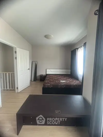 Spacious bedroom with modern decor and natural light, featuring a comfortable bed and sleek furnishings.