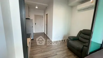 Modern apartment interior with sleek wooden flooring and cozy seating area.