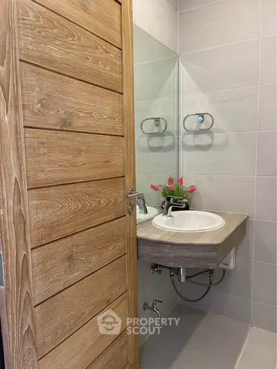 Modern bathroom with wooden door and sleek sink design