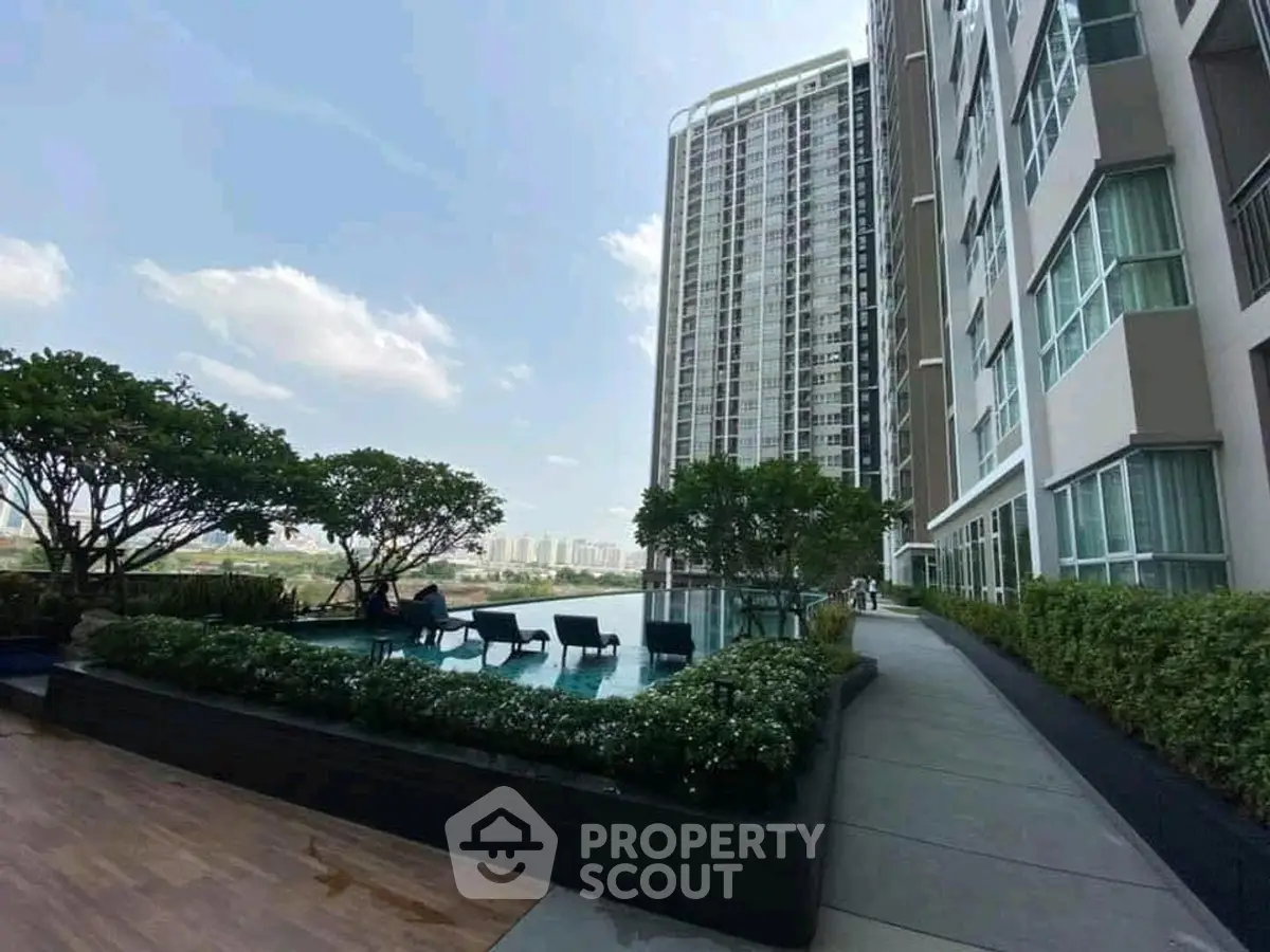 Modern high-rise building with rooftop pool and lush greenery offering stunning city views.