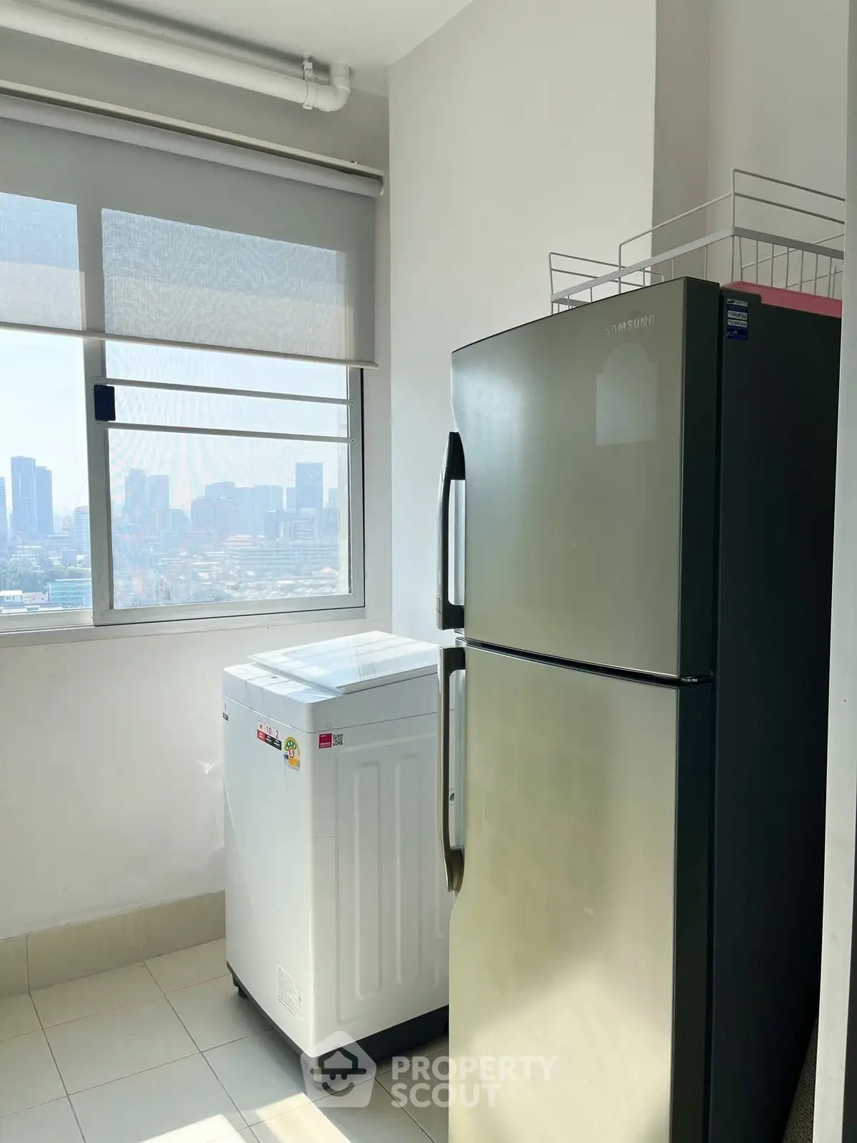 Bright utility room with city view, featuring a modern fridge and washing machine.