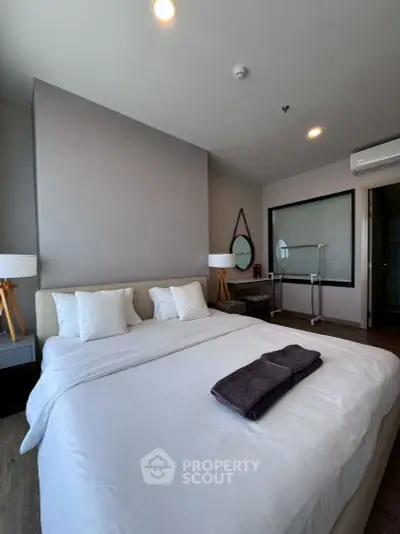 Modern bedroom with cozy bed and stylish decor in a contemporary apartment.
