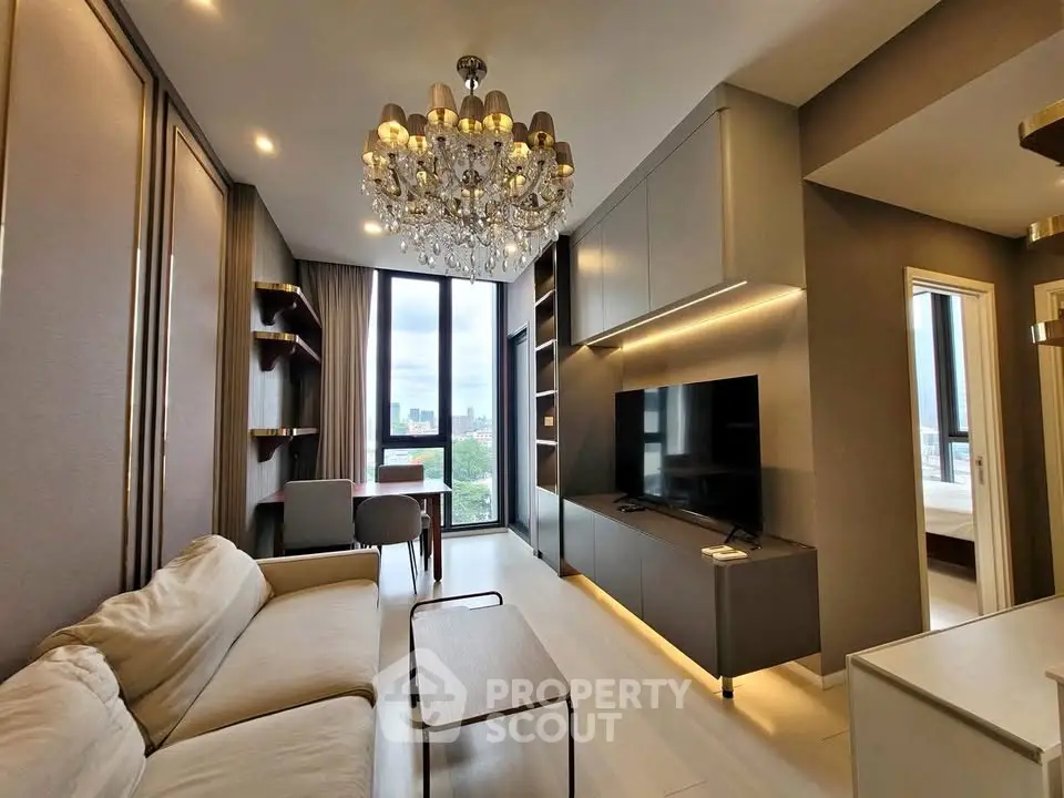 Luxurious modern living room with chandelier and city view, featuring elegant furniture and built-in storage.
