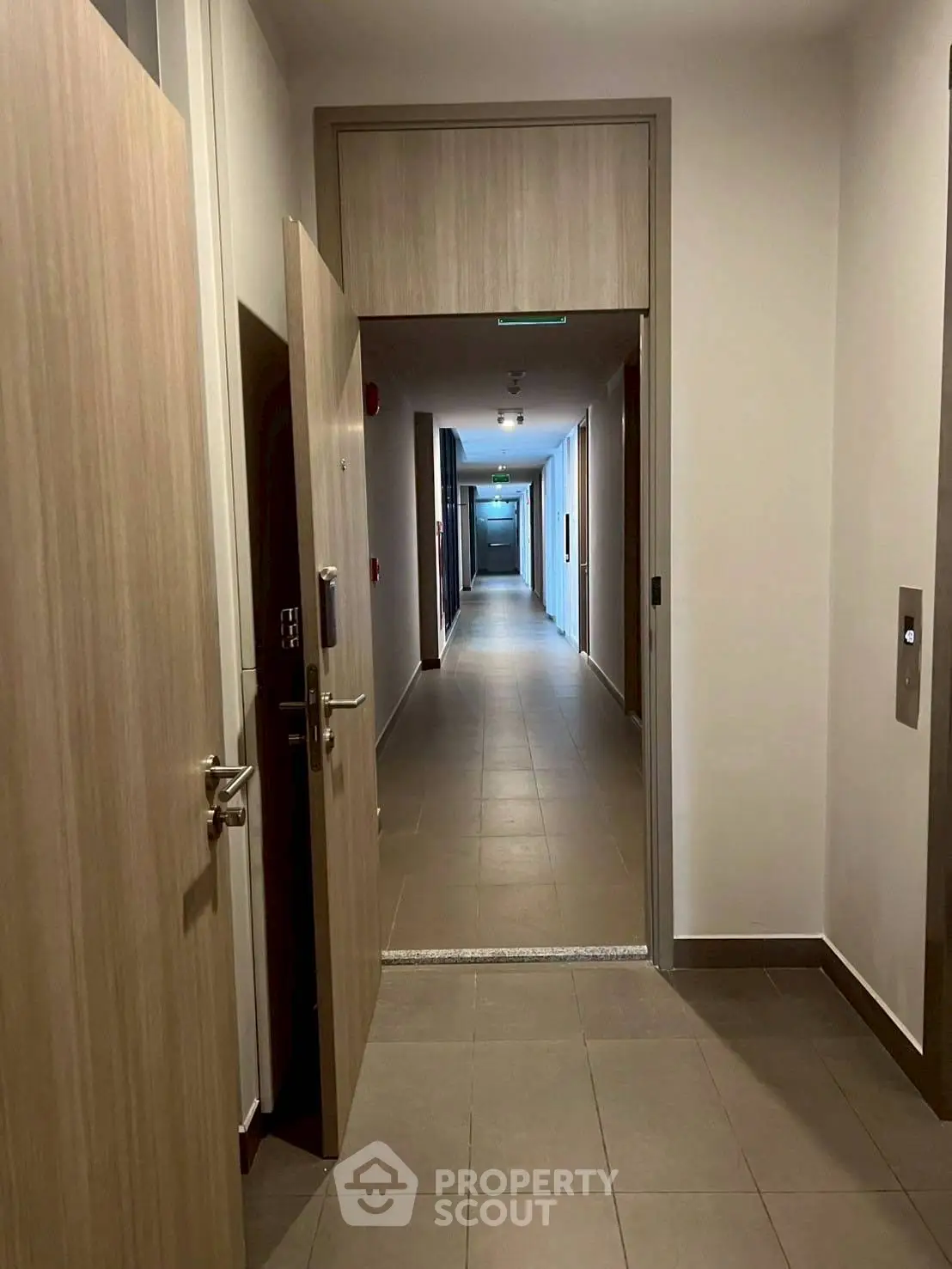 Modern apartment hallway with open door and elevator access