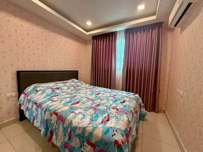 Cozy bedroom with patterned bedspread and elegant curtains