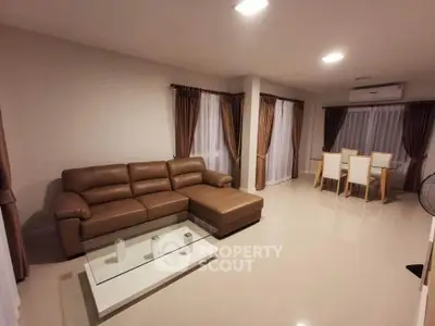 Spacious living room with modern brown leather sofa and elegant dining area