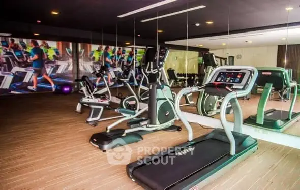 Modern gym with state-of-the-art fitness equipment in luxury residential building.
