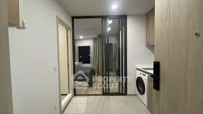 Modern apartment entrance with washing machine and view into bedroom
