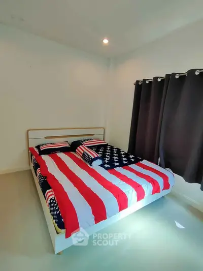Cozy bedroom with patriotic-themed bedding and dark curtains