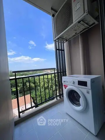 Charming balcony with scenic view and modern washing machine, perfect for urban living convenience.