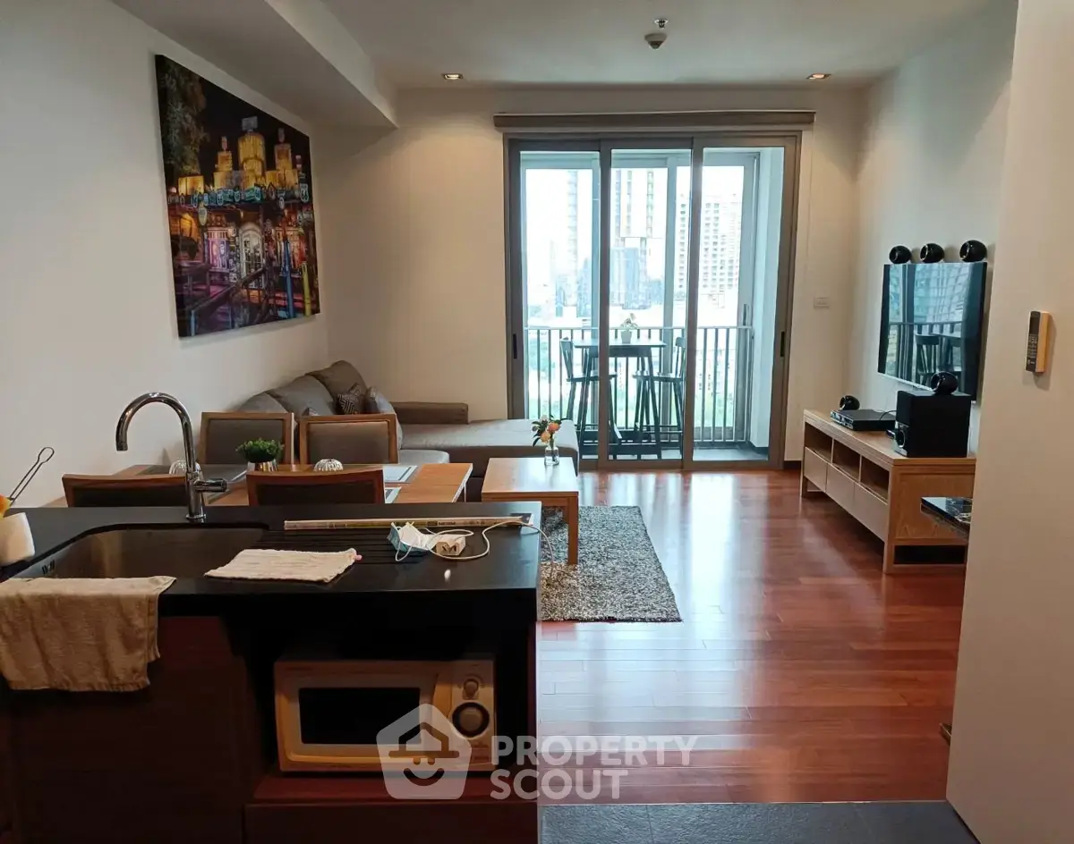Modern living room with open kitchen and balcony view in urban apartment