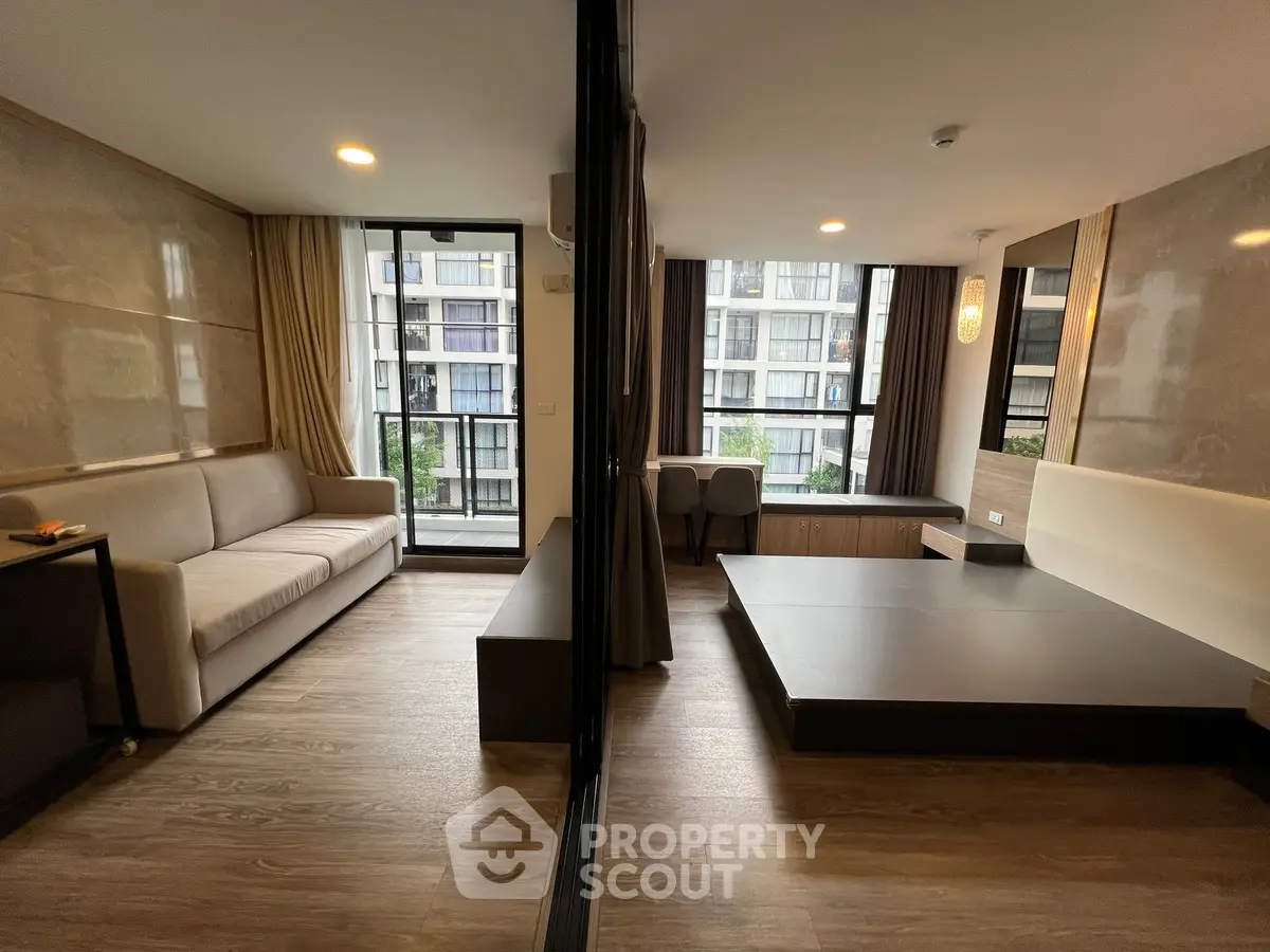 Modern living room with stylish decor and large windows offering a city view, perfect for urban living.