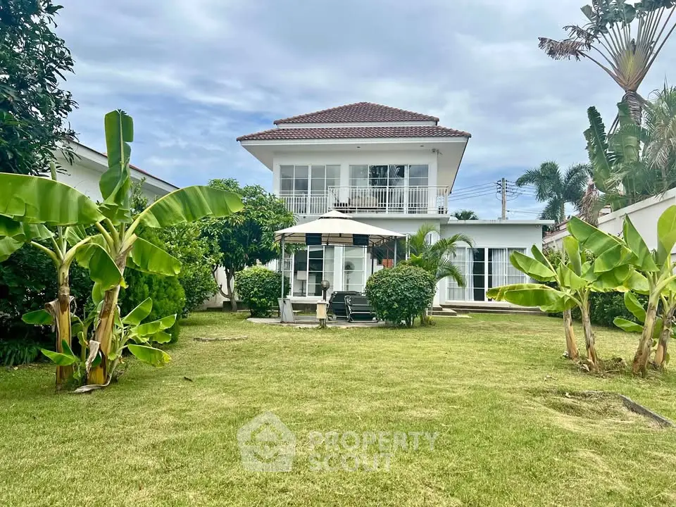 Charming two-story house with lush garden and patio, perfect for family living.