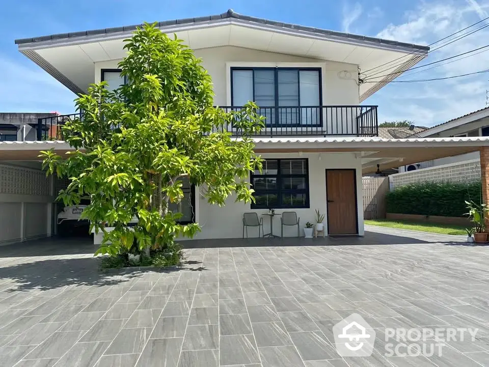 Modern two-story house with spacious driveway and lush greenery