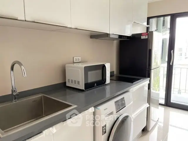 Modern kitchen with sleek appliances and balcony view