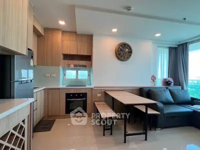 Modern open-layout kitchen and living area with sleek wooden finishes and stylish decor.
