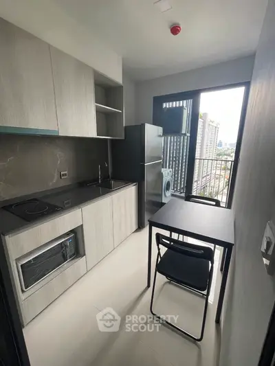 Modern compact kitchen with sleek appliances and city view from balcony