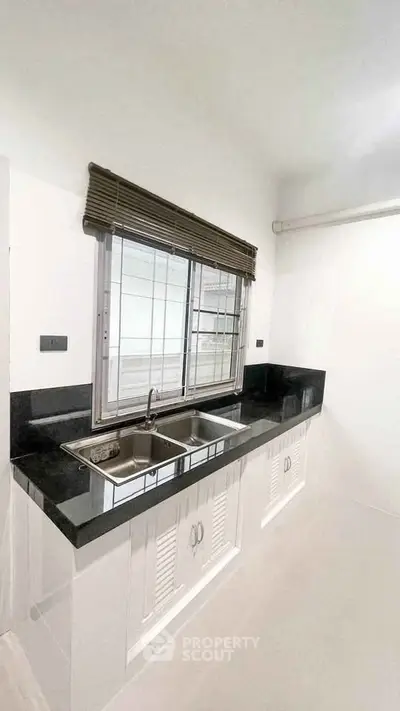 Modern kitchen with sleek black countertop and double sink
