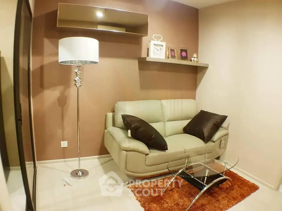 Cozy living room with modern sofa, glass coffee table, and stylish floor lamp in a chic apartment.