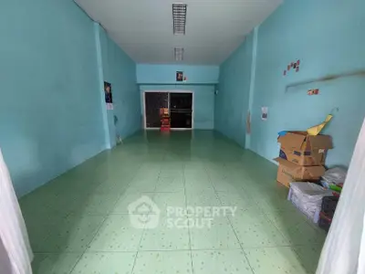 Spacious empty room with green tiled floor and blue walls, ideal for customization.