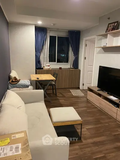 Cozy living room with modern decor, featuring a comfortable sofa, dining table, and large TV for entertainment.