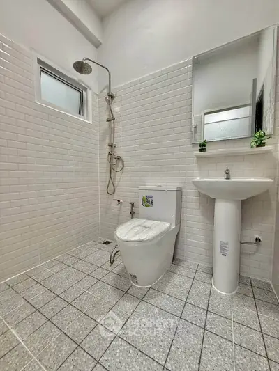 Modern bathroom with sleek white tiles and contemporary fixtures.